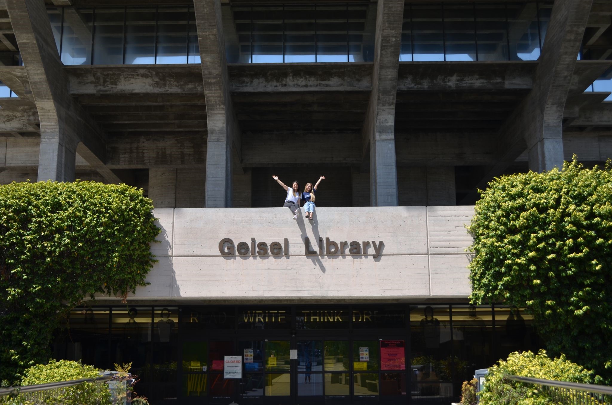 two people on to of Geisel sign